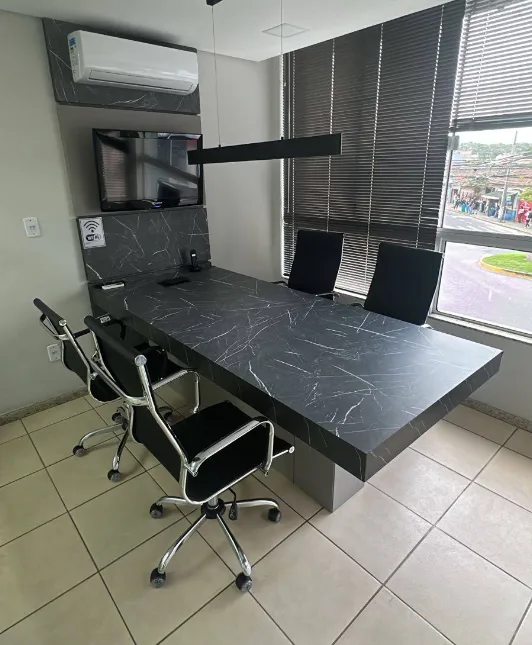 Sala de reuniões do escritório, com mesa ampla e cadeiras para atendimento
